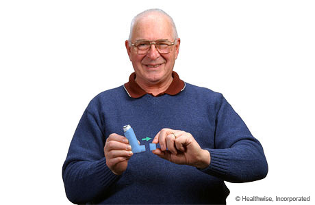 Un hombre retirando la tapa de un inhalador