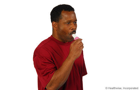 Hombre colocándose el inhalador en la boca
