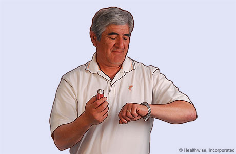 Foto de un hombre conteniendo la respiración y mirando su reloj para contar 10 segundos